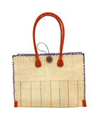 Zafran Two Tone Wide Stripe Blues Pinstripe Straw Beach Bag handmade loomed raffia palm fiber in a solid hue of natural straw color on the top half of the bag and a multicolor multi-width vertical pinstripe stripe pattern with thin bands of dusk navy/dark/blue, turquoise blue/green, light blue, seafoam light/blue/green and wide bands of natural straw color on the bottom half of the bag with leather handles and feet and matching crosshatch stitch edging shoulder bag - Shebobo