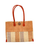 Zafran Two Tone Wide Stripe Blush Swirl Straw Beach Bag handmade loomed raffia palm fiber in a solid hue of blush orange/pink on the top half of the bag and a multicolor multi-width vertical stripe pattern of blush, grey, and natural straw color on the bottom half of the bag with leather handles and feet and matching crosshatch stitch edging shoulder bag - Shebobo