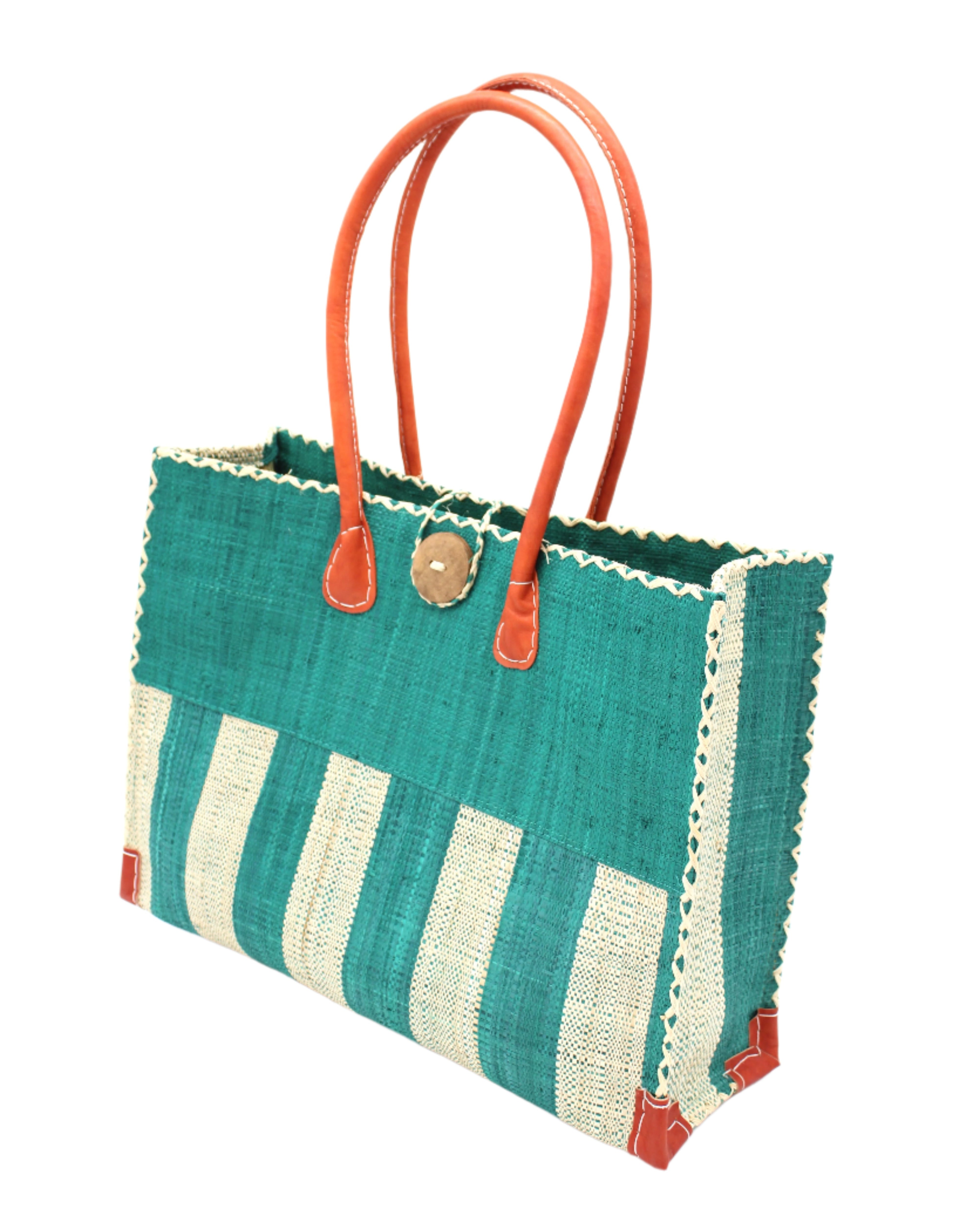 Side view Zafran Two Tone Wide Stripe Teal and Natural Straw Beach Bag handmade loomed raffia palm fiber in a solid hue of teal dark/blue/green on the top half of the bag and a two tone even width vertical wide stripe pattern of teal and natural straw color on the bottom half of the bag with leather handles and feet and matching crosshatch stitch edging shoulder bag - Shebobo