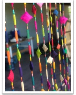 Zola Garland Multicolor Raffia Pillow Bead Strands Room Decor Festive beaded strands of handmade loomed raffia pillow beads, hand wrapped long raffia loop beads, and painted plastic beads in bright, bold, fun colors (sold as single strand or pack of 10 Strands) - Shebobo