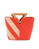 Zuki Two Tone Coral Straw Handbag With Wood Triangle Handle handmade loomed raffia palm fiber in a two tone pattern with the left half of the bag even width stripes of coral orange/red and natural straw color oriented as a diagonal stripe and the right half of the bag a solid hue of coral with carved wood handles - Shebobo