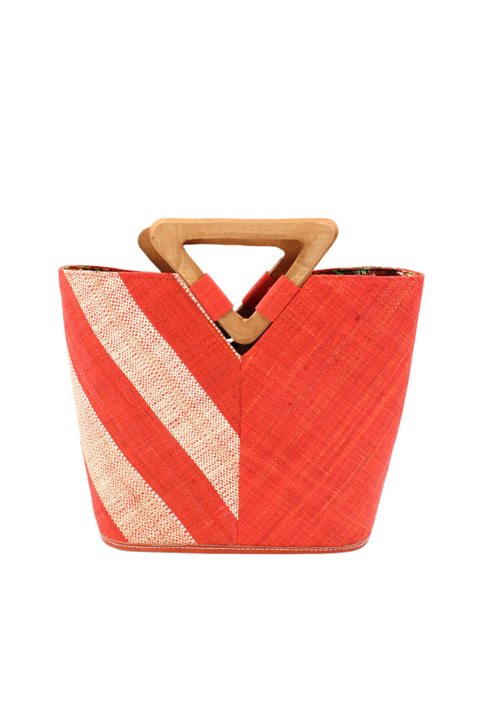 Zuki Two Tone Coral Straw Handbag With Wood Triangle Handle handmade loomed raffia palm fiber in a two tone pattern with the left half of the bag even width stripes of coral orange/red and natural straw color oriented as a diagonal stripe and the right half of the bag a solid hue of coral with carved wood handles - Shebobo