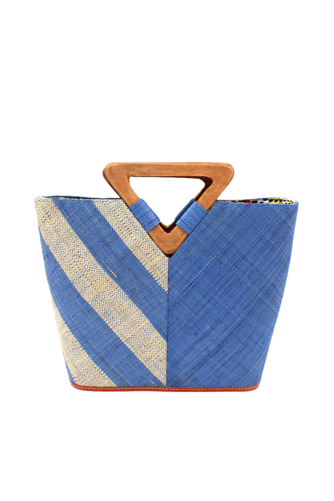 Zuki Two Tone Denim Straw Handbag With Wood Triangle Handle handmade loomed raffia palm fiber in a two tone pattern with the left half of the bag even width stripes of denim retro/light/blue and natural straw color oriented as a diagonal stripe and the right half of the bag a solid hue of denim with carved wood handles - Shebobo