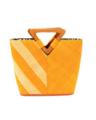 Zuki Two Tone Saffron Straw Handbag With Wood Triangle Handle handmade loomed raffia palm fiber in a two tone pattern with the left half of the bag even width stripes of saffron yellow/orange and natural straw color oriented as a diagonal stripe and the right half of the bag a solid hue of saffron with carved wood handles - Shebobo