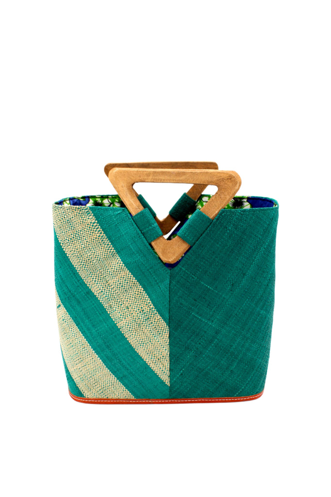 Zuki Two Tone Teal Straw Handbag With Wood Triangle Handle handmade loomed raffia palm fiber in a two tone pattern with the left half of the bag even width stripes of teal dark/blue/green and natural straw color oriented as a diagonal stripe and the right half of the bag a solid hue of teal with carved wood handles - Shebobo