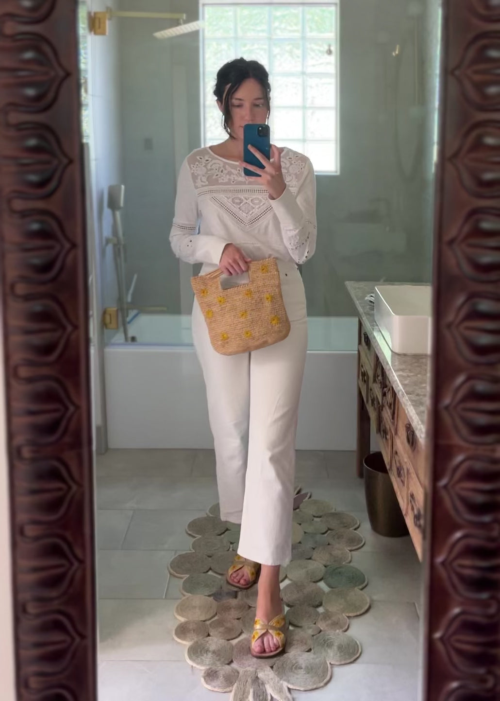 Model wearing Daisy Crochet Straw & Leather Sandal with Flower Embroidery & Metallic Detailing handmade crochet natural raffia palm fiber in a solid hue of natural straw color in two bands with saffron yellow petals and coral orange/red centered embroidered flower pattern wrap around the top  of the shoe with a band of metallic gold across the top summer sandals shoes - Shebobo (with Mini Concon Flower Embroidery Straw Basket Purse)