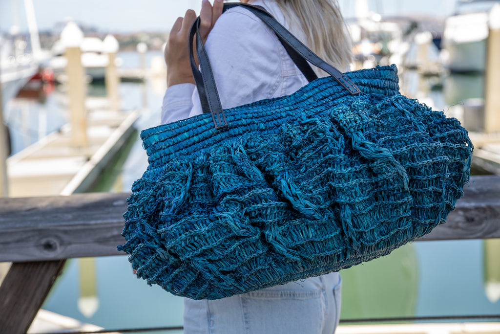 Model wearing Bella crochet large straw handbag handmade turquoise blue boho purse with leather handles bag - Shebobo