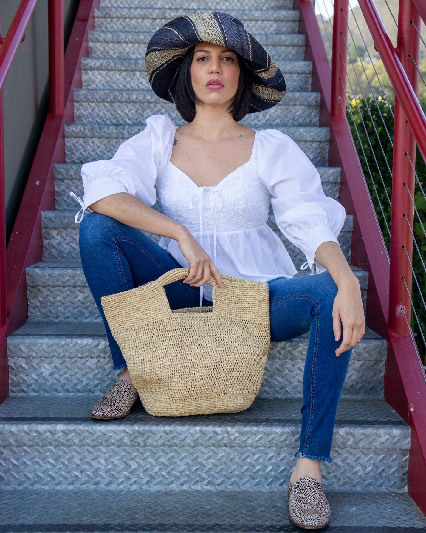 Model wearing ConCon crochet straw basket natural raffia straw color handbag textural bag - Shebobo (with 5" Brim Black Swirl Packable Straw Sun Hat)
