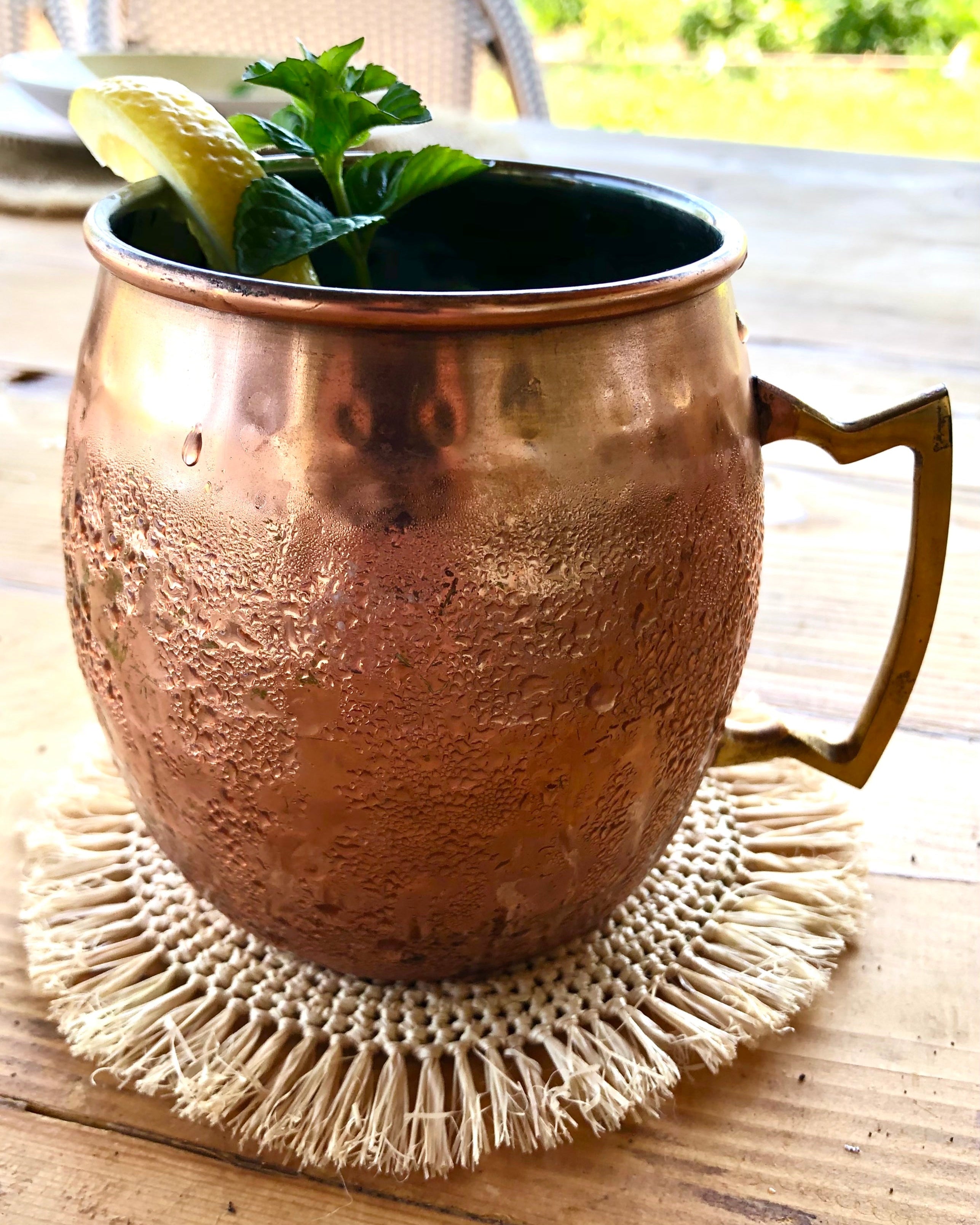Detail view Imani Crochet Raffia Coasters set of four handmade natural raffia palm fiber crochet in a solid hue of natural straw color table setting protectors with brushed fringe edge with a spiral circular subtle texture - Shebobo