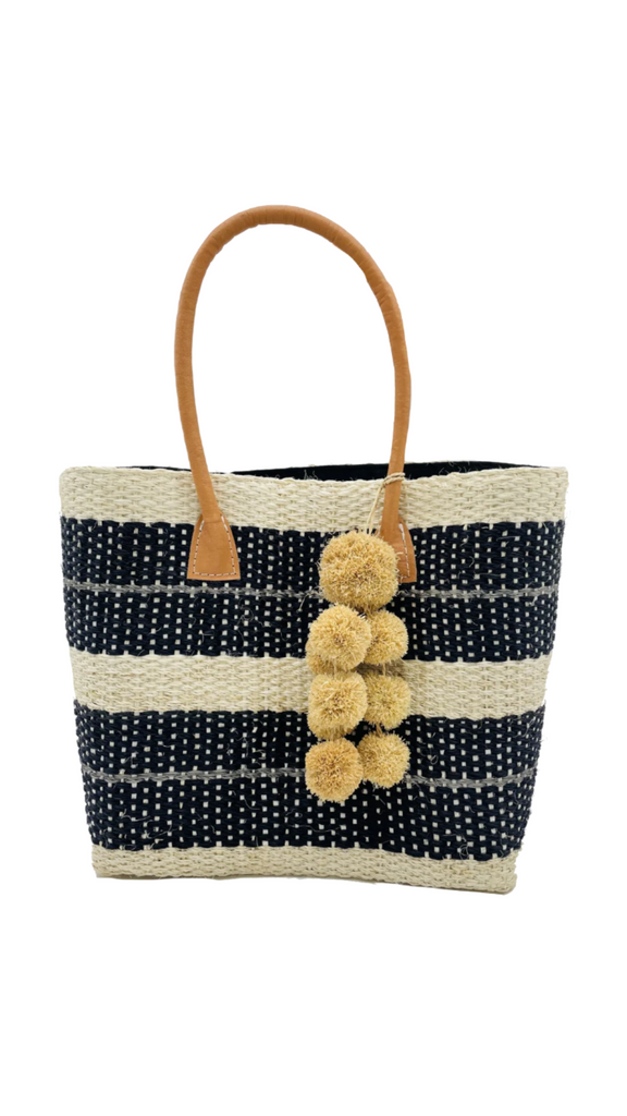 Imperial sisal basket natural straw color, black, and grey horizontal multi-width stripe pattern handmade woven natural sisal fiber basket bag with raffia waterfall pompom charm embellishment handbag - Shebobo