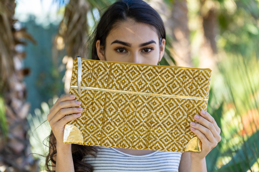 Model wearing Inverness Woven Straw Clutch with Gold Accents handmade zippered pouch purse woven raffia cinnamon/tobacco/brown and natural two tone contrasting diamond pattern - Shebobo