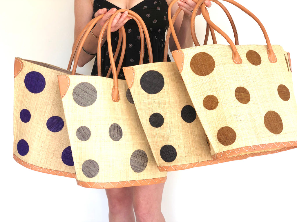 Model wearing multiple options of Capri Polka Dot Straw Tote Bag blue, grey, black, and cinnamon dots handbags with leather handles - Shebobo